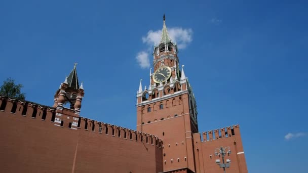 Ściana Kremla, zegar na Spasskaja wieża Kremla przed błękitnym niebem w słoneczny letni dzień. Plac Czerwony w Moskwie, stolicy Rosji. Centrum miasta, punkt turystyczny. — Wideo stockowe