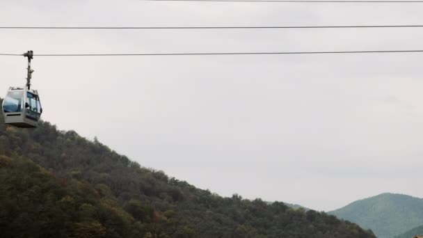 Caminho de cabo de elevador de esqui para transporte de pessoas na montanha de verão. Elevador de cadeiras na colina, céu cinzento. Teleférico levanta turistas em resort de luxo — Vídeo de Stock