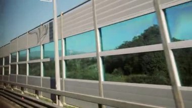 İnsanları araba gürültüsünden korumak için. Güvenli modern otoyolda yüksek hızlı hareket eden otomobil. Güneşli bir günde otomobille seyahat etmek. Araba penceresinden görüntüle