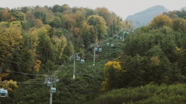 Montanha estação de elevação de esqui no outono. O teleférico eleva as pessoas ao topo das rochas de verão em resort de luxo. Viajar para as montanhas — Vídeo de Stock