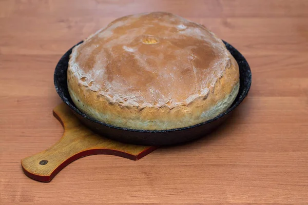 Kurnik, Russian pie with chicken, onion and potatoes. A traditional dish of dough lies on the table.