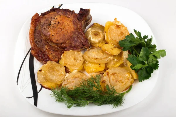 roast meat with potatoes and onions on a plate on a white background