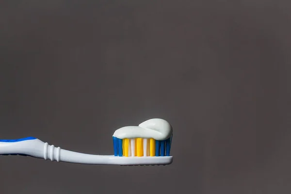 toothbrush with toothpaste isolated on grey background