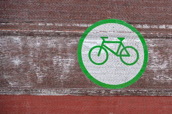 Huge bicycle sign on a brick wall, encouraging people to ride bikes.