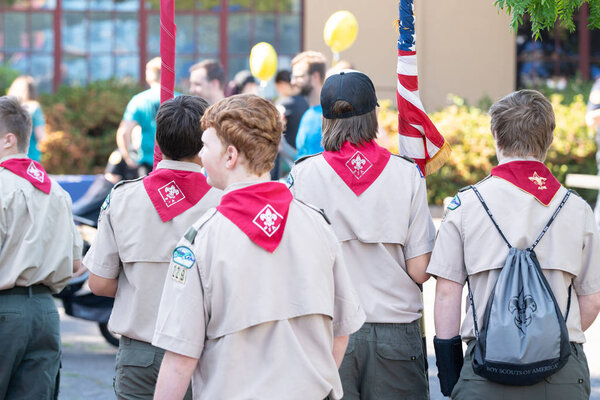 Portland, OR / USA - August 18 2018: Boy scouts walking down the street with the wrapped american flag.