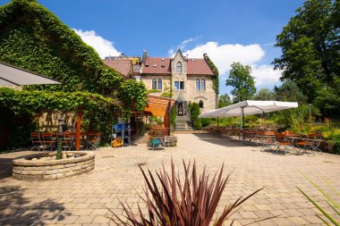 Schloss Lichtenstein, Almanya - Jyly 24 2015: Cafe güneşli bir Alman Kalesi plaza önünde.