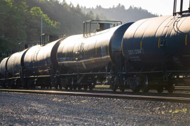 Portland, ya da / Amerika Birleşik Devletleri - 26 Haziran 2018: siyah sıvı taşıma vagon petrol, gaz ve dizel demiryolu gibi malların tesliminde günbatımında izler.