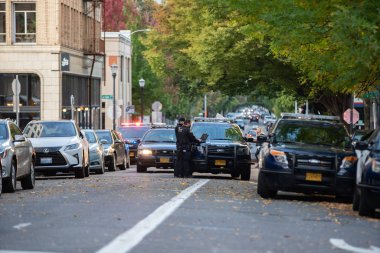 Portland, ya da / Amerika Birleşik Devletleri - 6 Ekim 2018: birden fazla polis arabaları bir sokakta şehir merkezinde akşam engelleme. İki polis olay yerinde dizüstü bilgisayarlar ile.
