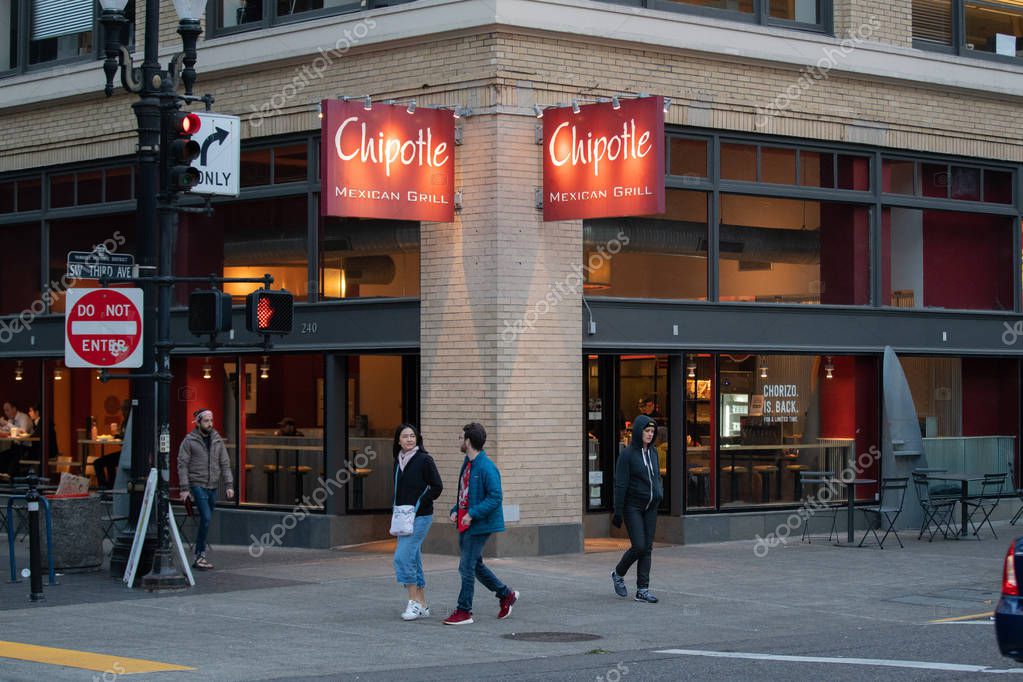 Portland, OR / USA - October 6 2018: Chipotle Mexican grill restaurant with people walking in front of it.