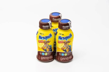 Portland, OR / USA - October 8 2018: Three Nesquik by Nestle company chocolate milk bottles with drink for kids on light background clipart