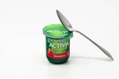 Portland, ya da / Amerika Birleşik Devletleri - 8 Ekim 2018: Activia Dannon probiyotik yoğurt üzerine metal bir kaşıkla yeşil plastik bir kap içinde.