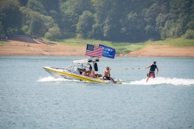 Hagg Lake, ya da / Amerika Birleşik Devletleri - 19 Ağustos 2018: motoru Amerikan ve yanlısı trump bayrakları ile gölde. Teknenin arkasında su kayağı kişi.