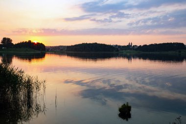 Aukstadvaris, Litvanya gölde üzerinde dramatik turuncu günbatımı.