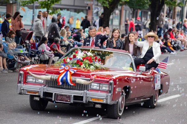 Portland, ya da / Amerika Birleşik Devletleri - 11 Haziran 2016: büyük çiçek geçit töreni. İnsanların sürüş eski vintage caddede Kırmızı Cadillac çiçeklerle süslenmiş..