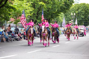 Portland, ya da / Amerika Birleşik Devletleri - 11 Haziran 2016: büyük çiçek geçit töreni, ata binerek pembe kovboy kostümü yetişkin kadın grubu. Az sayıda kadın Amerikan bayrakları taşıyan.