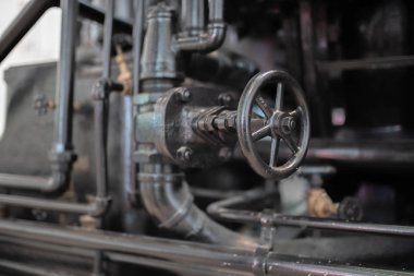 Endüstriyel siyah boru hattı, bir vintage elektrik üretimi makineye besleme üzerinde büyük vana.