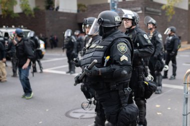 Portland, OR / USA - November 17 2018: Police in heavy riot gear during protest turned into civil disobedience. clipart