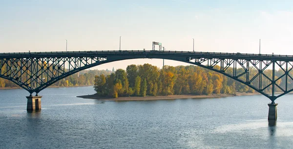 Ross island bridge in Portland, Oregon. Arc shaped cantilever truss bridge across Willamette river; connects east and west city sides.