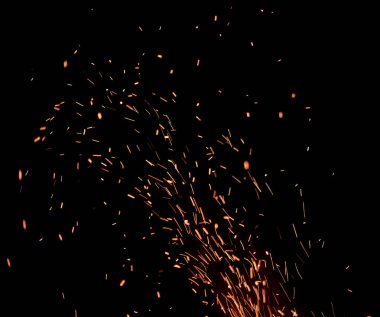 Siyah arka plan üzerine izole bir alev üzerinden yüksekten uçuyor Sparks.