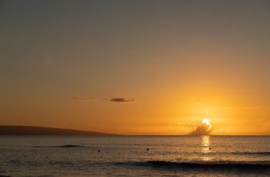 Maui, Hawaii Pasifik Okyanusunda ufukta bulutun içine güneş ayarı ile tropikal günbatımı.