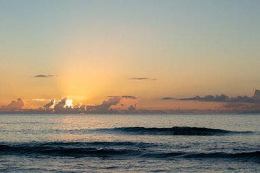 Güneş gibi bulutlardan parlayan günün son ışınları Maui, Hawaii Pasifik Okyanusu içine setleri.