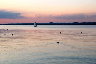 Konstanz Gölü ile Yelkenli tekneler ve kuğuları, güzel gün batımı