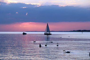 Gemi ve kuğular gölde güzel renkli gün batımı