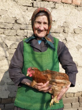 Tavuk elinde tutan Doğu Avrupa üst düzey çiftçi kadın