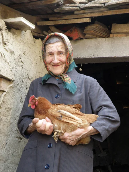 Tavuk elinde tutan Doğu Avrupa eski çiftçi kadın