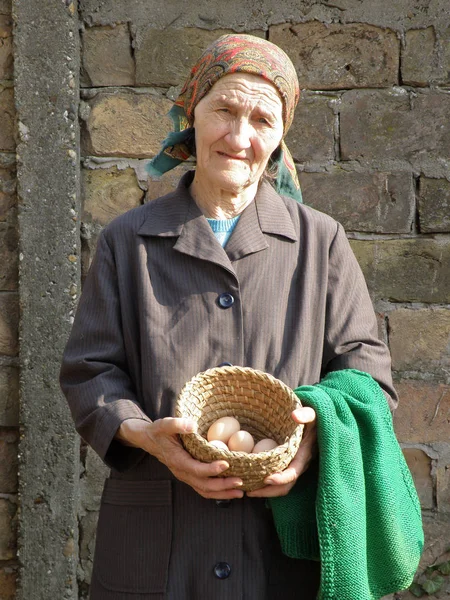 Eastern european senior farmer woman holding eggs in her hands