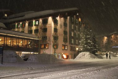 Lech, Avusturya - 04 01 2018: Güzel kış gecesi sokakta Lech, Avusturya kayak tatil köyü dağ evi ve Snowing ile