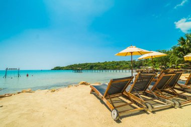 Şemsiye ve güzel tropikal plaj ve deniz paradise Island Seyahat ve tatil için Hindistan cevizi hurma ağacı ile sandalye