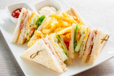 Club sandviç pastırma peynir, jambon sebze ve sos beyaz plaka ile