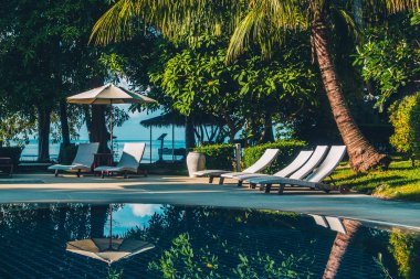 Güzel lüks otel ve tatil seyahat ve tatil için sandalye ve şemsiye ile açık yüzme havuzu