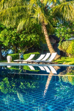 Güzel lüks otel ve tatil seyahat ve tatil için sandalye ve şemsiye ile açık yüzme havuzu