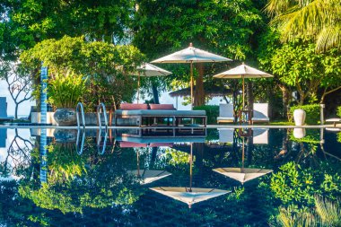 Güzel lüks otel ve tatil seyahat ve tatil için sandalye ve şemsiye ile açık yüzme havuzu