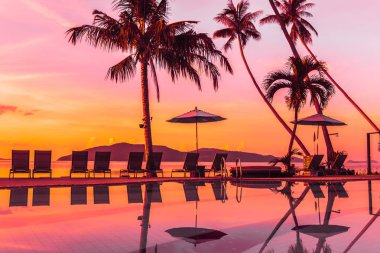 Şemsiye ve lüks otel ve gündoğumu zaman seyahat ve tatil için Resort'ta yüzme havuzu etrafında sandalye ile güzel açık görünüm