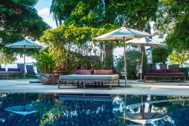 Güzel lüks otel ve tatil seyahat ve tatil için sandalye ve şemsiye ile açık yüzme havuzu