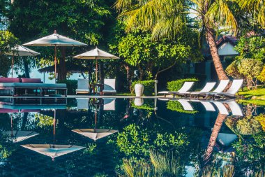 Güzel lüks otel ve tatil seyahat ve tatil için sandalye ve şemsiye ile açık yüzme havuzu