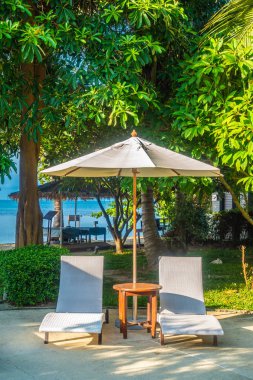 Güzel lüks otel ve tatil seyahat ve tatil için sandalye ve şemsiye ile açık yüzme havuzu