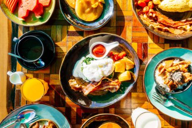 Sağlıklı kahvaltı seti yumurta pastırma ile portakal suyu süt ekmek kahve ve diğer ahşap masada krep