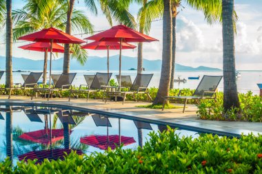 Güzel lüks otel ve tatil seyahat ve tatil için sandalye ve şemsiye ile açık yüzme havuzu