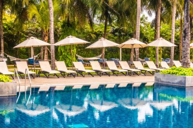 Güzel lüks otel ve tatil seyahat ve tatil için sandalye ve şemsiye ile açık yüzme havuzu