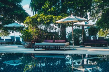 Güzel lüks otel ve tatil seyahat ve tatil için sandalye ve şemsiye ile açık yüzme havuzu