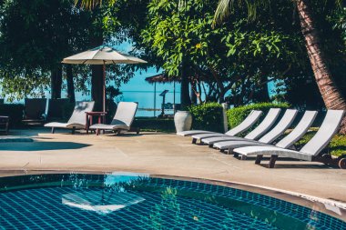 Güzel lüks otel ve tatil seyahat ve tatil için sandalye ve şemsiye ile açık yüzme havuzu