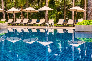 Güzel lüks otel ve tatil seyahat ve tatil için sandalye ve şemsiye ile açık yüzme havuzu