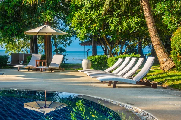 Güzel lüks otel ve tatil seyahat ve tatil için sandalye ve şemsiye ile açık yüzme havuzu