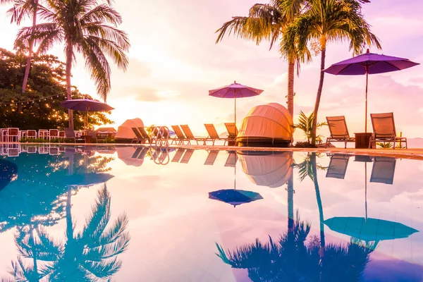 傘と椅子の高級ホテルと旅行や休暇の日の出時刻でリゾートのスイミング プールの周りの美しい屋外の眺め — ストック写真