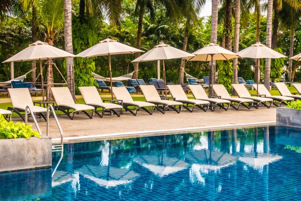 美丽的豪华室外游泳池 带雨伞和椅子在酒店和度假胜地旅行 — 图库照片