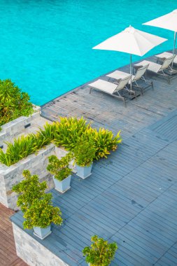 Güzel lüks şemsiye ve sandalye otel ve seyahat ve tatil için tatil yüzme havuzunda çevresinde
